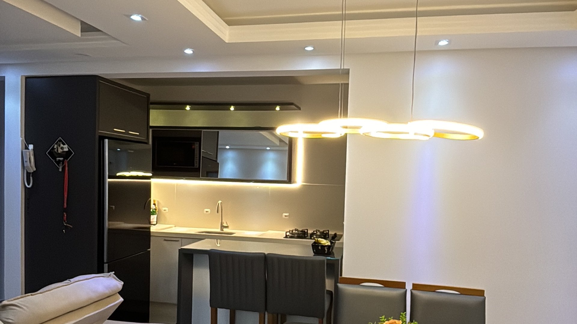 Cozinha com pendente de LED sobre a mesa e LED sob os armários
