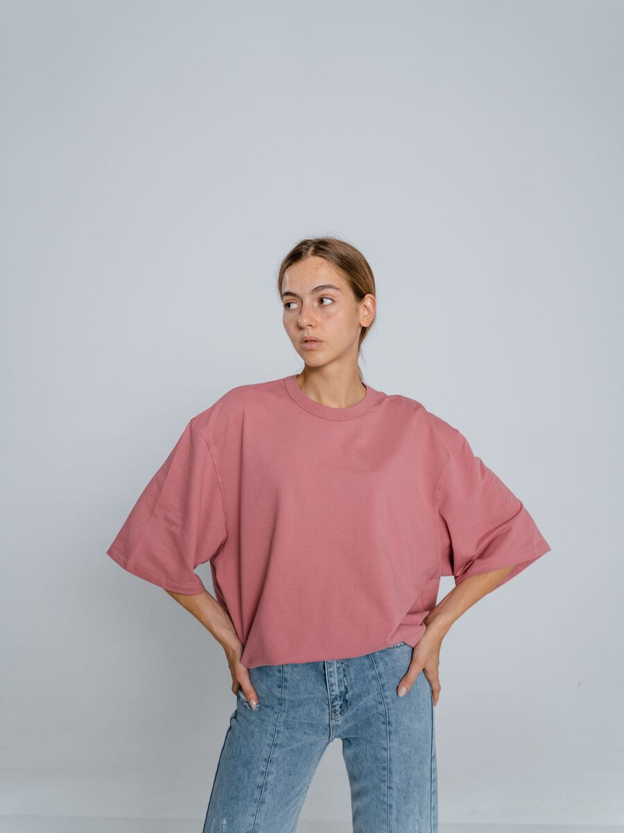 Modelo com camiseta rosa oversized e calça jeans